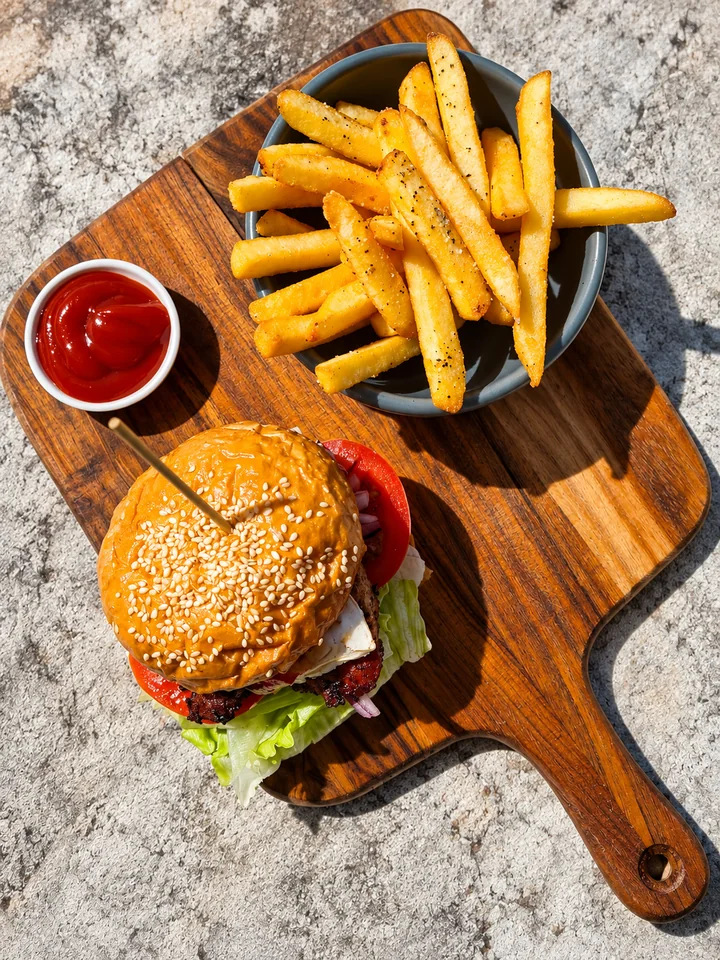 Burger and fries served on a wooden board
