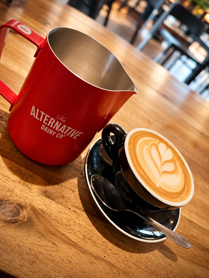 Latte beside a red milk jug